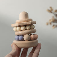 a hand carrying lightweight wooden stacking and building blocks for babies or toddlers